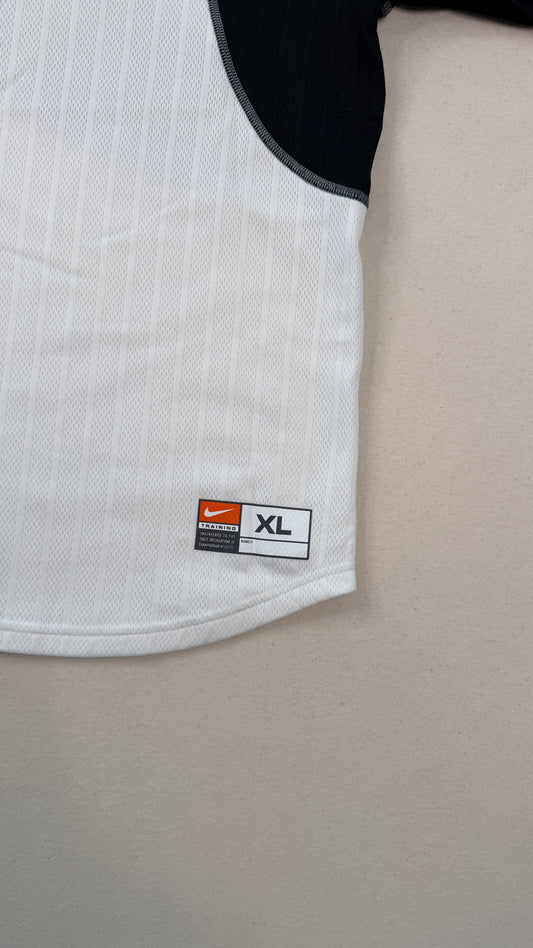 Close-up of a white shirt with an XL size label on a beige surface