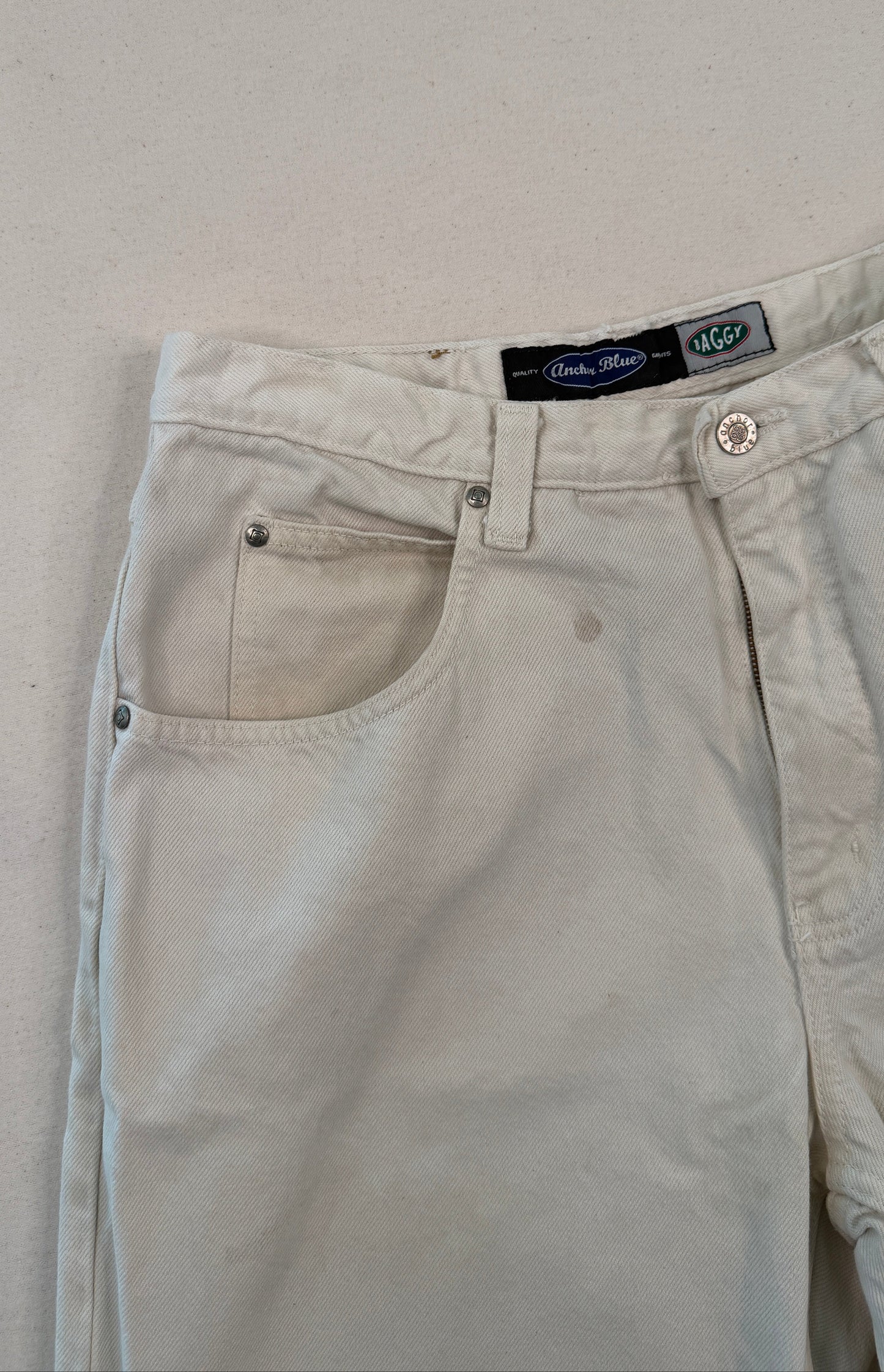 Beige pants with a brand label on a light gray background