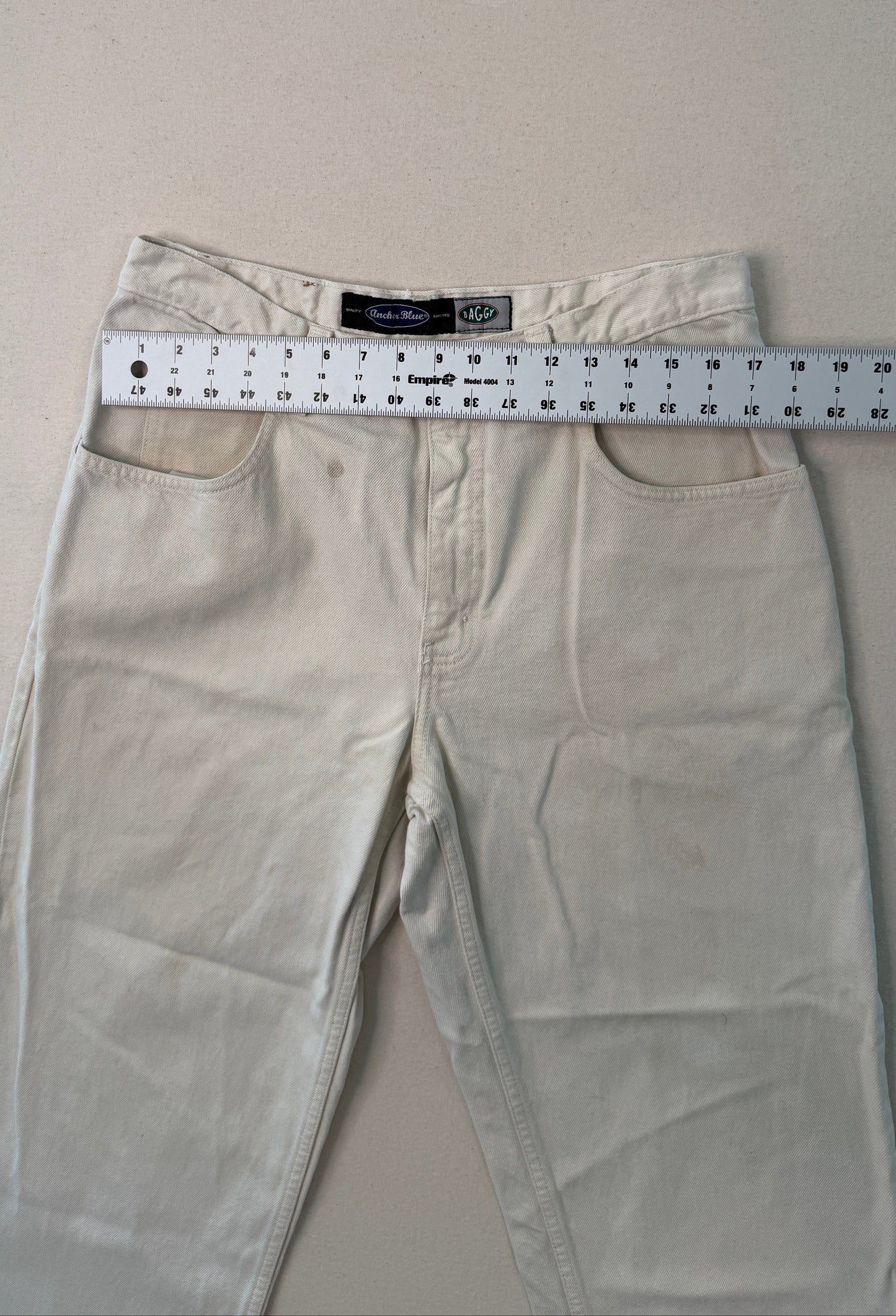 Beige pants with a measuring tape on a light gray background