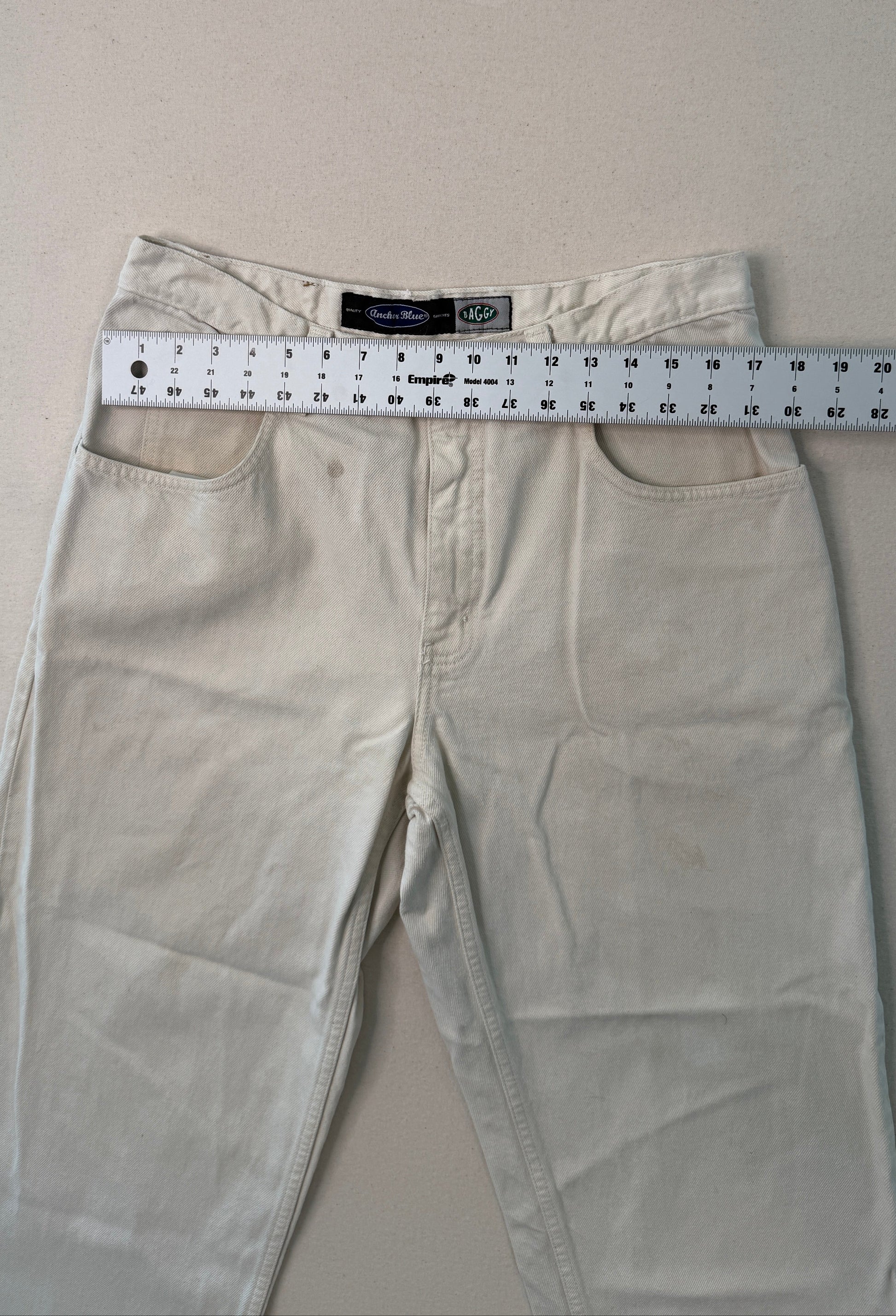 Beige pants with a measuring tape on a light gray background