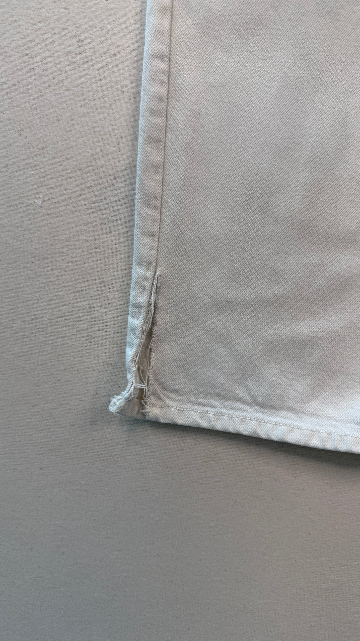 Close-up of a beige fabric corner on a plain background