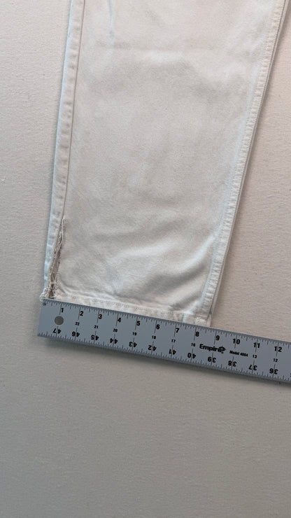Close-up of light-colored fabric with a ruler at the bottom for scale on a neutral background