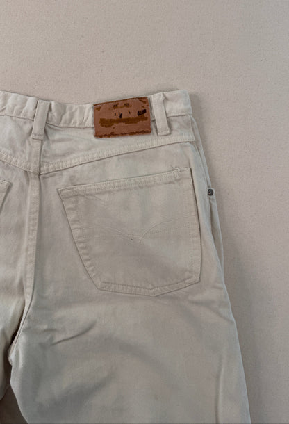 Light-colored pants with a brown belt buckle on a light gray background