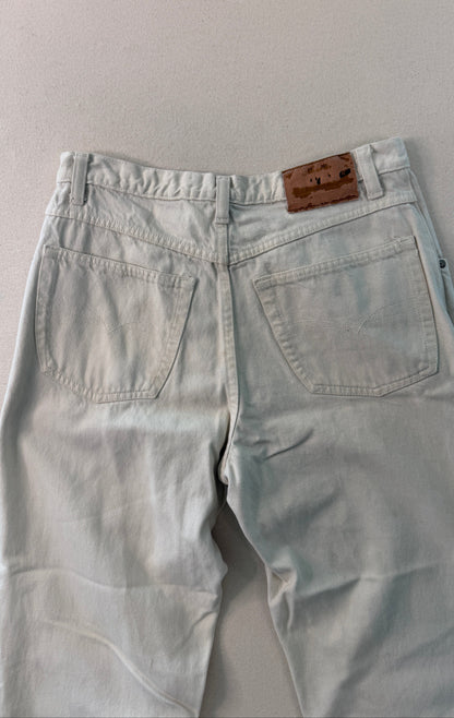 Light blue jeans with a brown leather patch on a gray background