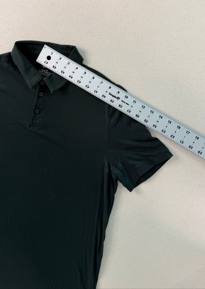 Black polo shirt with a ruler on a beige surface