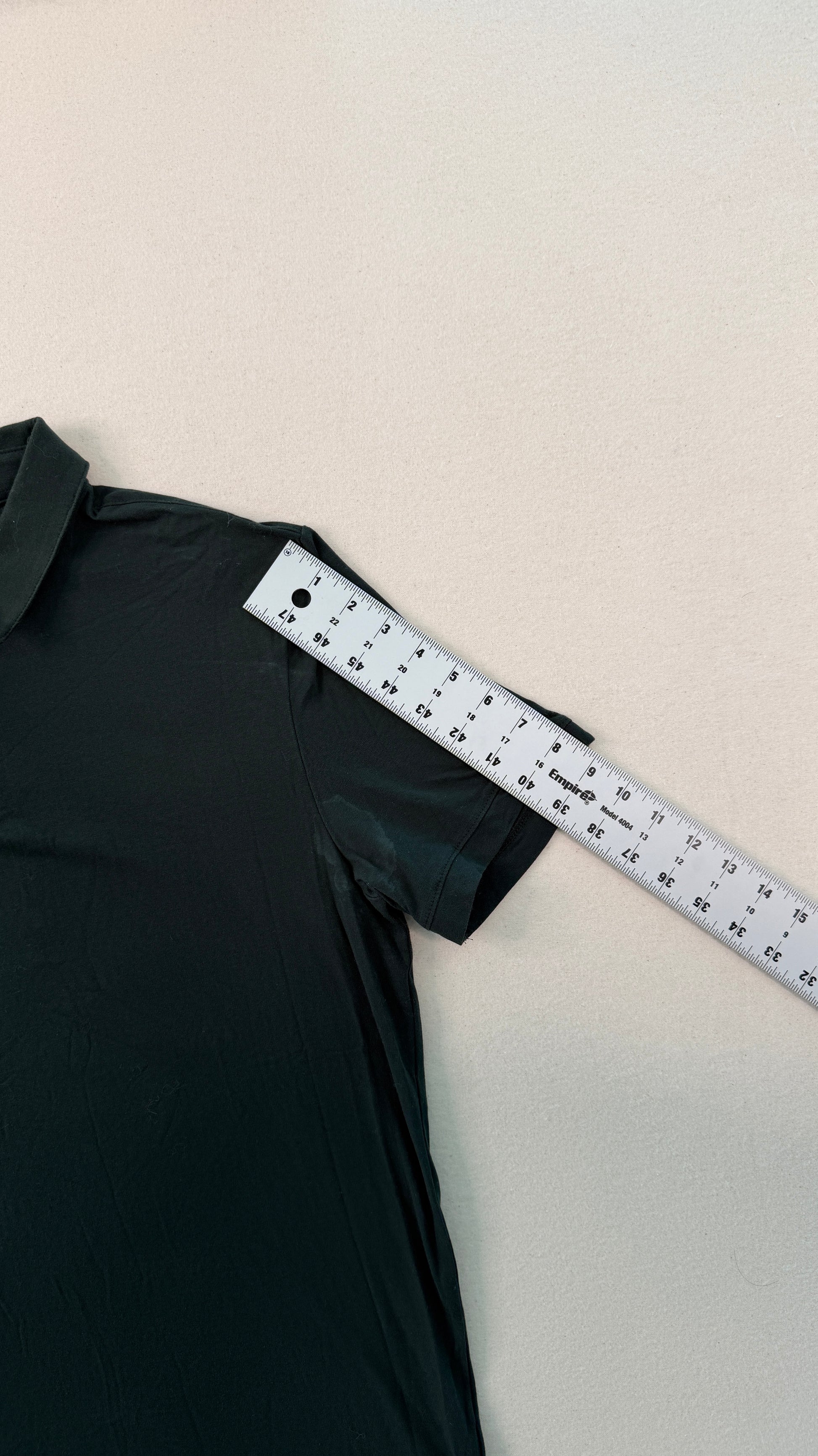 Black dress with a measuring tape on a beige background