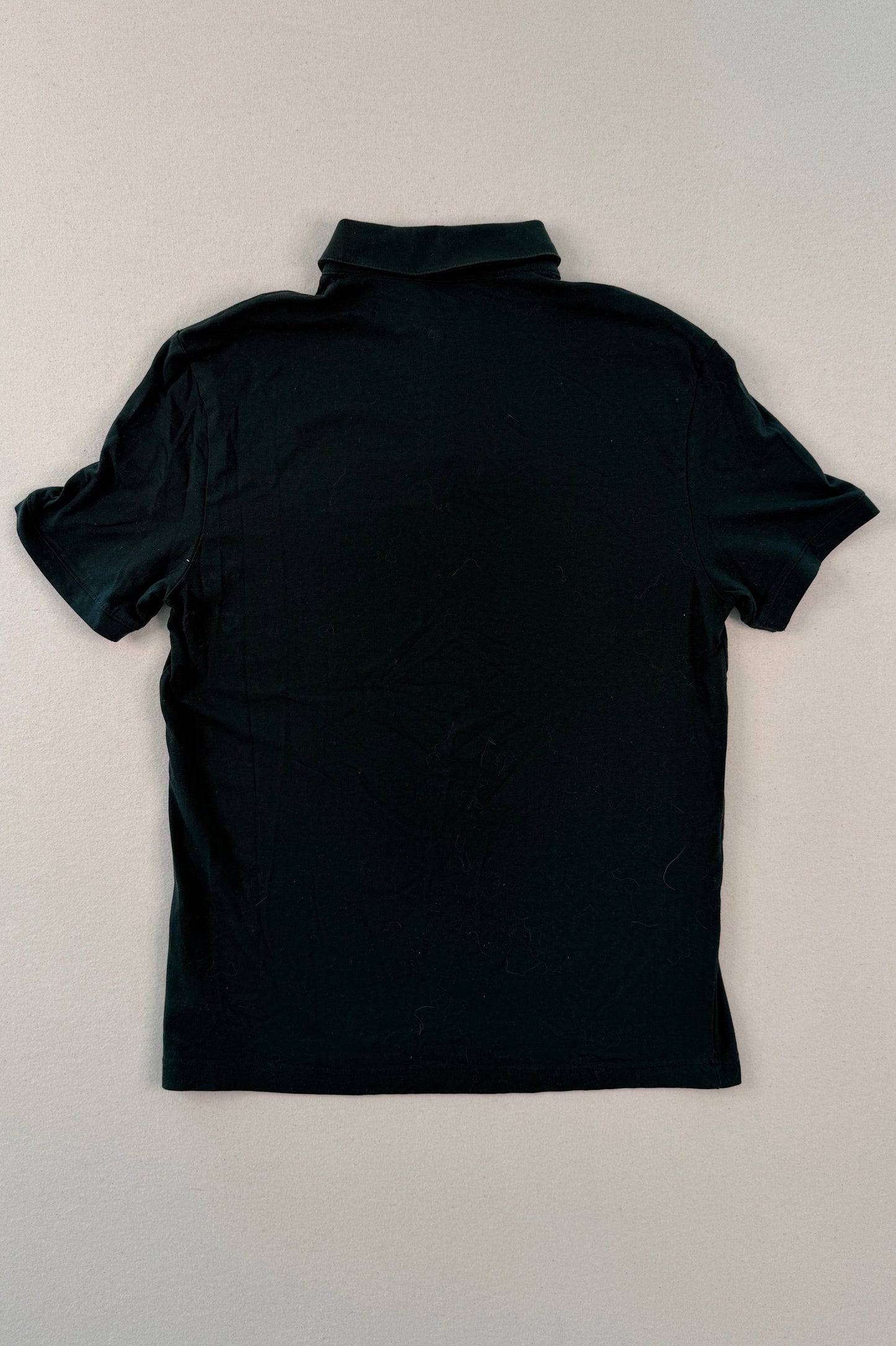 Black turtleneck shirt on a beige surface