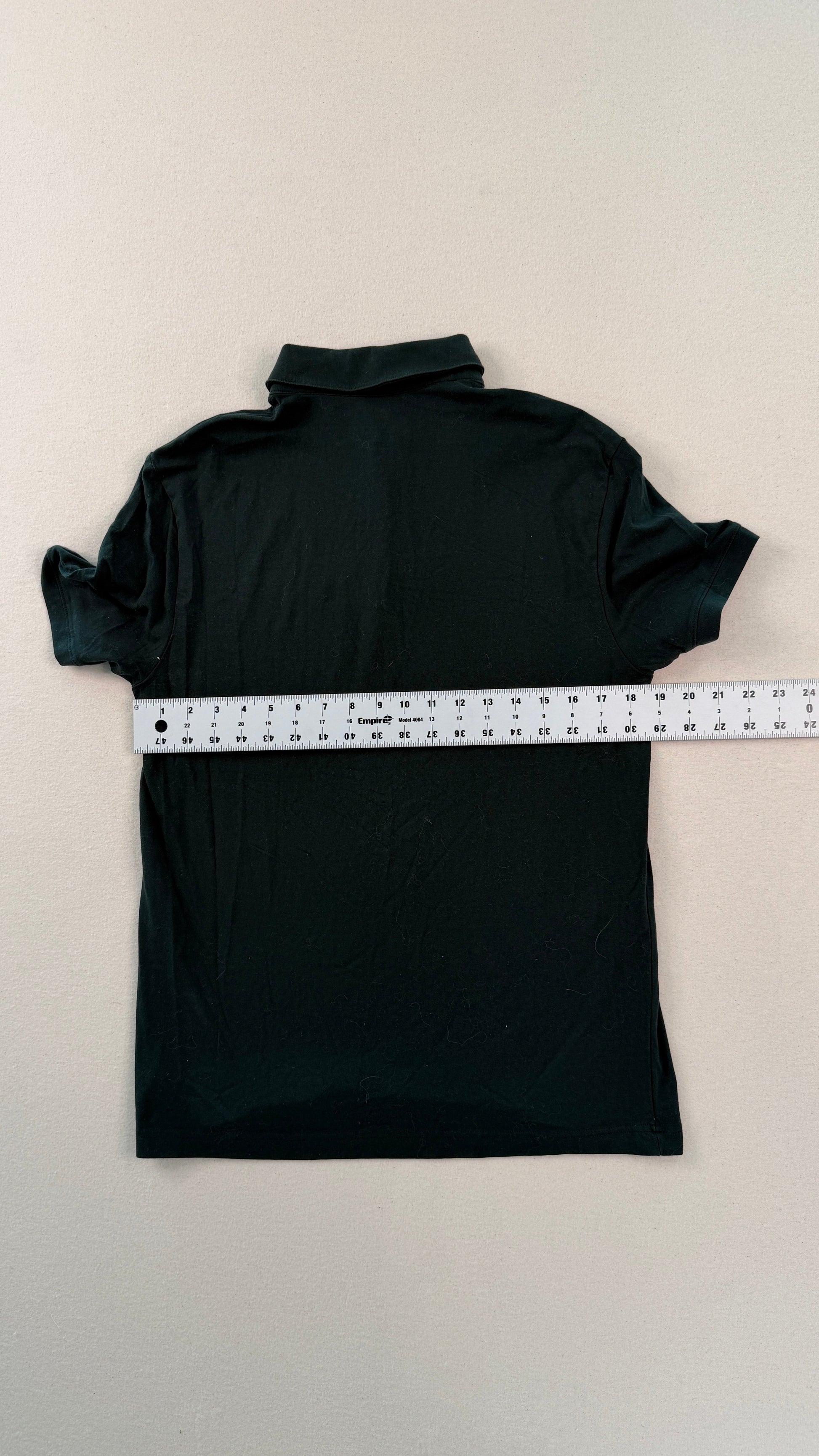 Black turtleneck shirt with a measuring tape on a beige background
