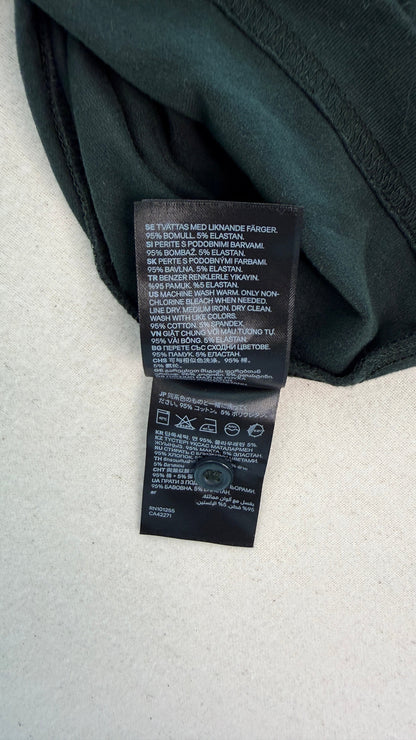 Close-up of a black label on a dark green fabric background