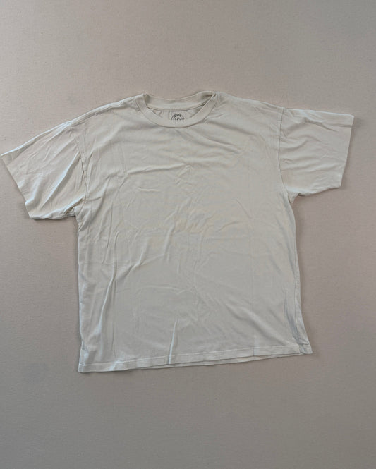 White t-shirt on a light gray surface with a ruler at the bottom.