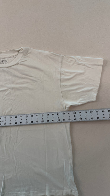 White t-shirt with a measuring tape laid across it on a plain background