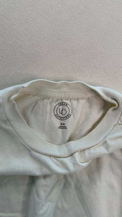 Close-up of a white t-shirt with a brand logo on a light gray background