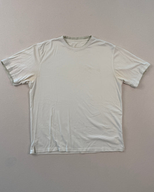 White t-shirt on a gray surface with a ruler at the bottom.