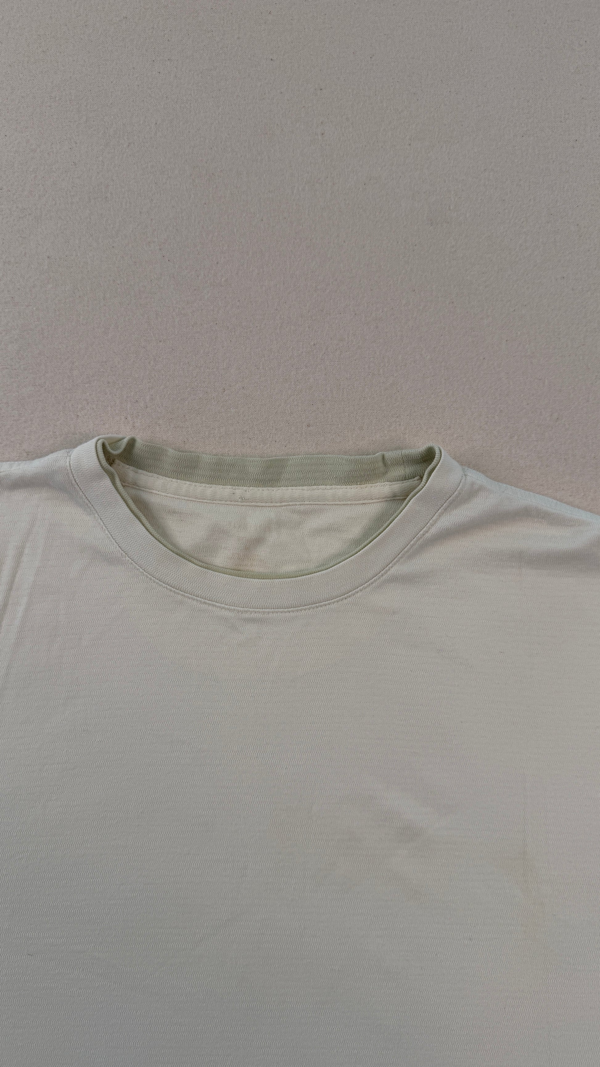 Plain light gray t-shirt on a matching gray background
