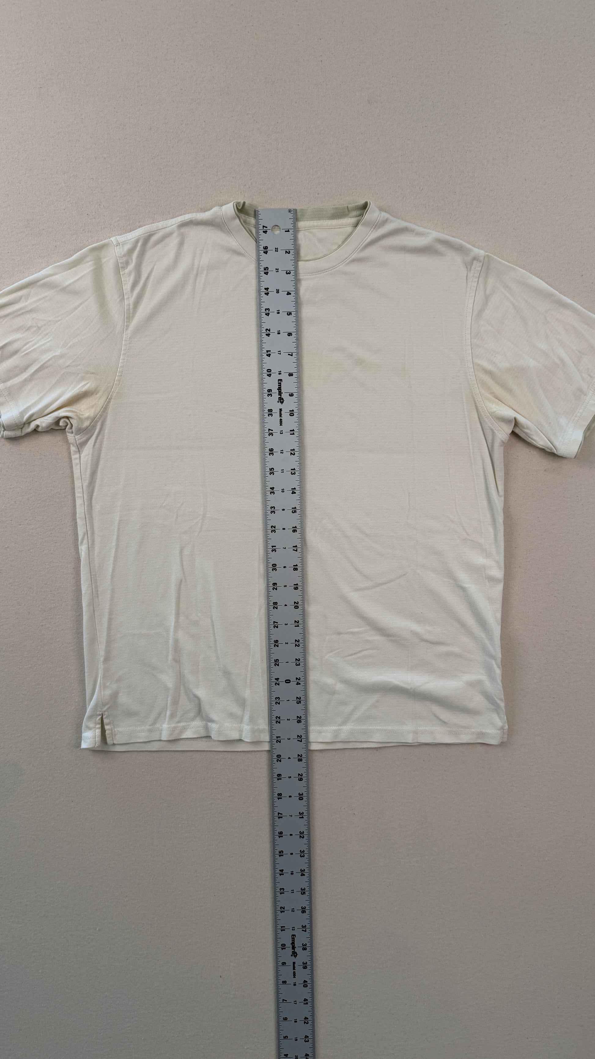White long-sleeve shirt with a ruler for size reference on a plain background