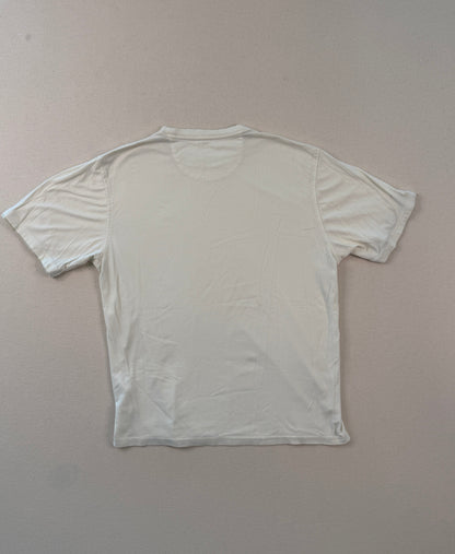 White t-shirt on a light gray surface with a ruler at the bottom.