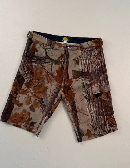 Camouflage-patterned shorts on a white surface with a ruler for scale.