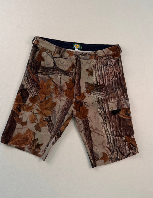 Camouflage-patterned shorts on a white surface with a ruler for scale.
