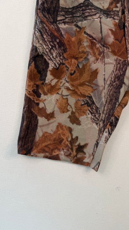 Tie with a nature-themed pattern featuring leaves and branches on a white background