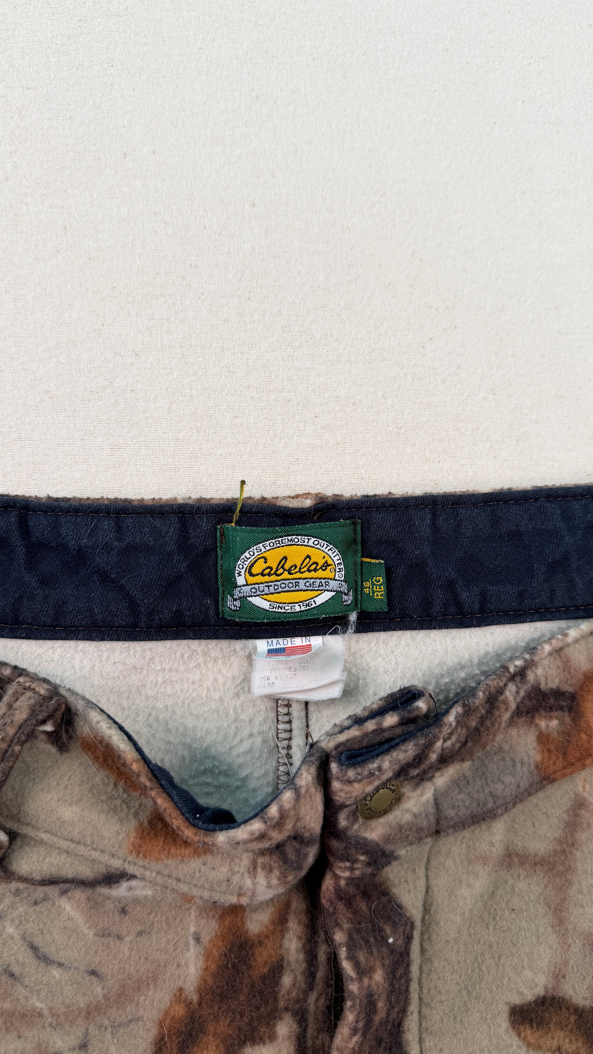 Cabela's branded belt with camouflage pattern on a white background