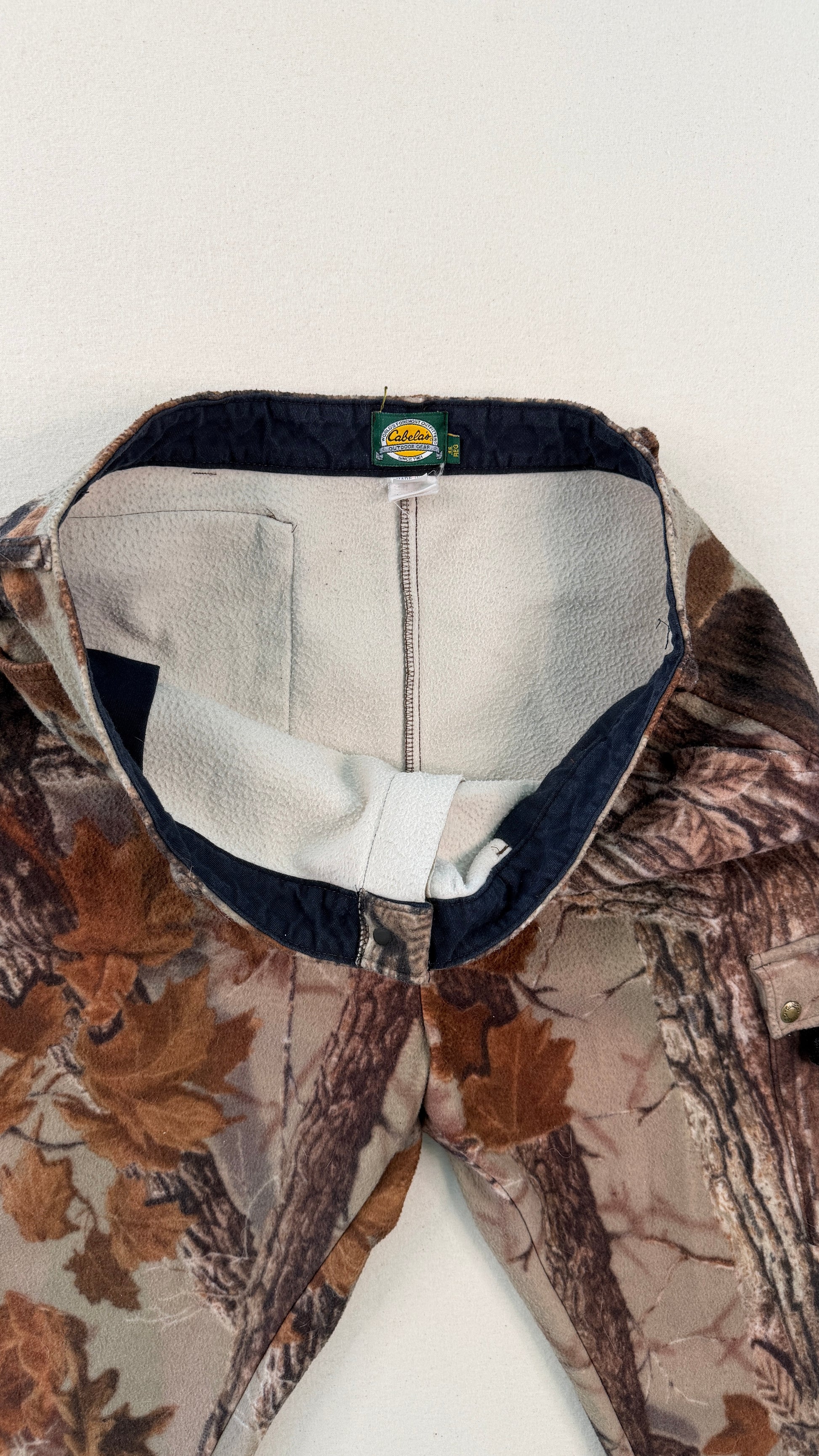 Close-up of a camouflage jacket with a visible brand logo on a white background