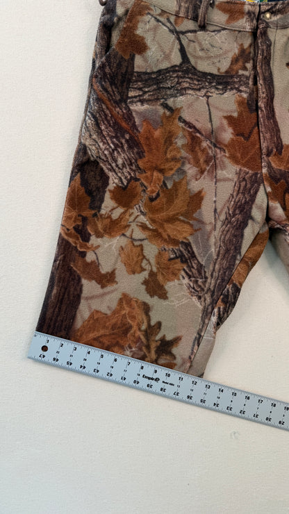 Camouflage-patterned pants with a ruler for scale on a white background