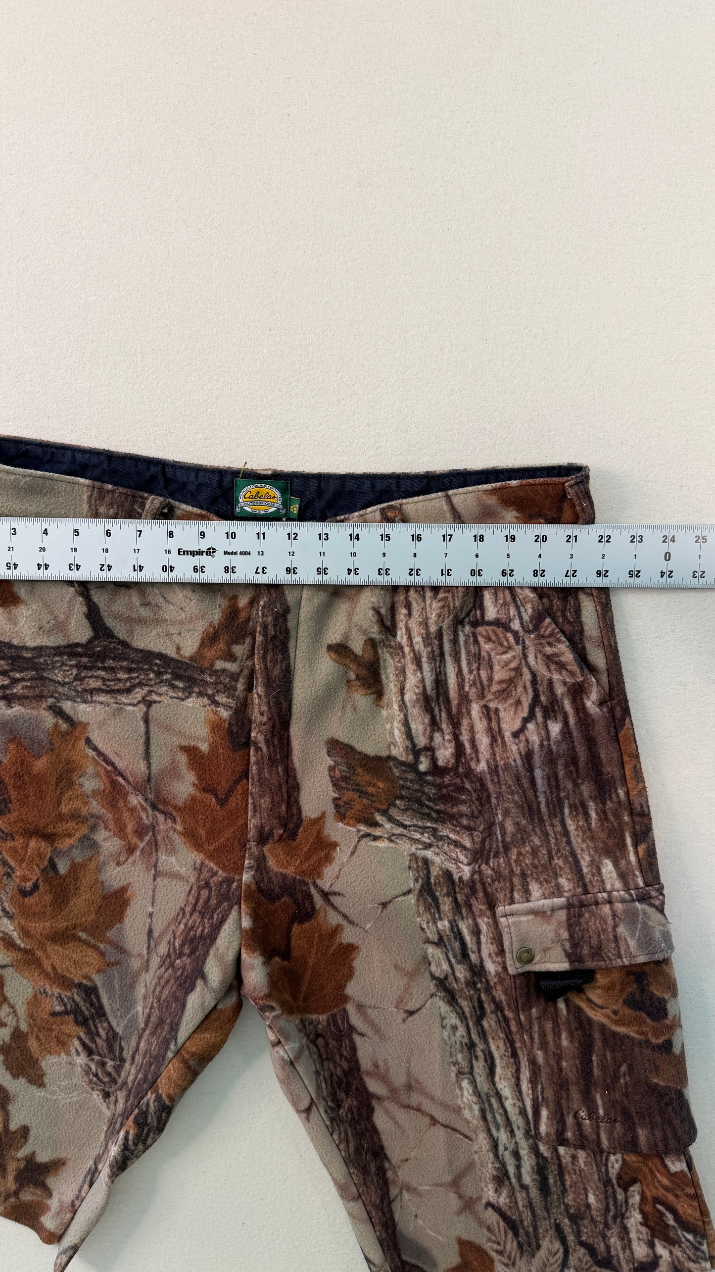 Camouflage pants with a measuring tape on a white background