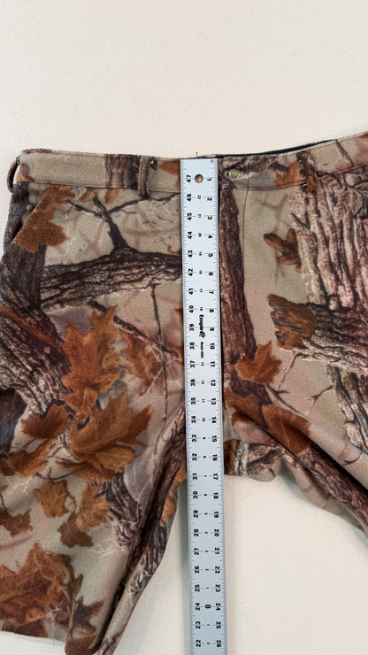 Camouflage pants with a measuring tape displayed on a white background