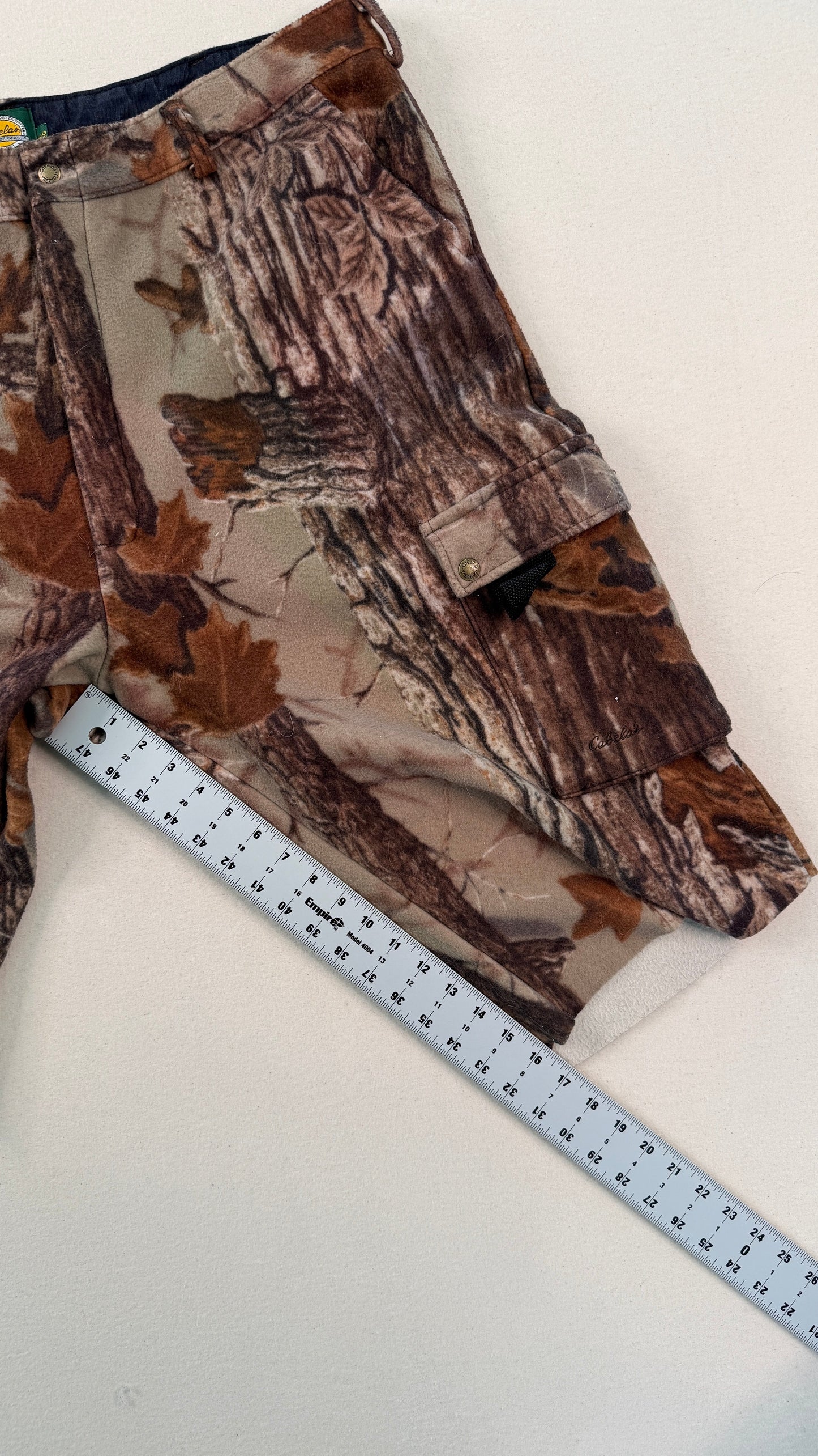 Camo-patterned fabric with a ruler for scale on a white background