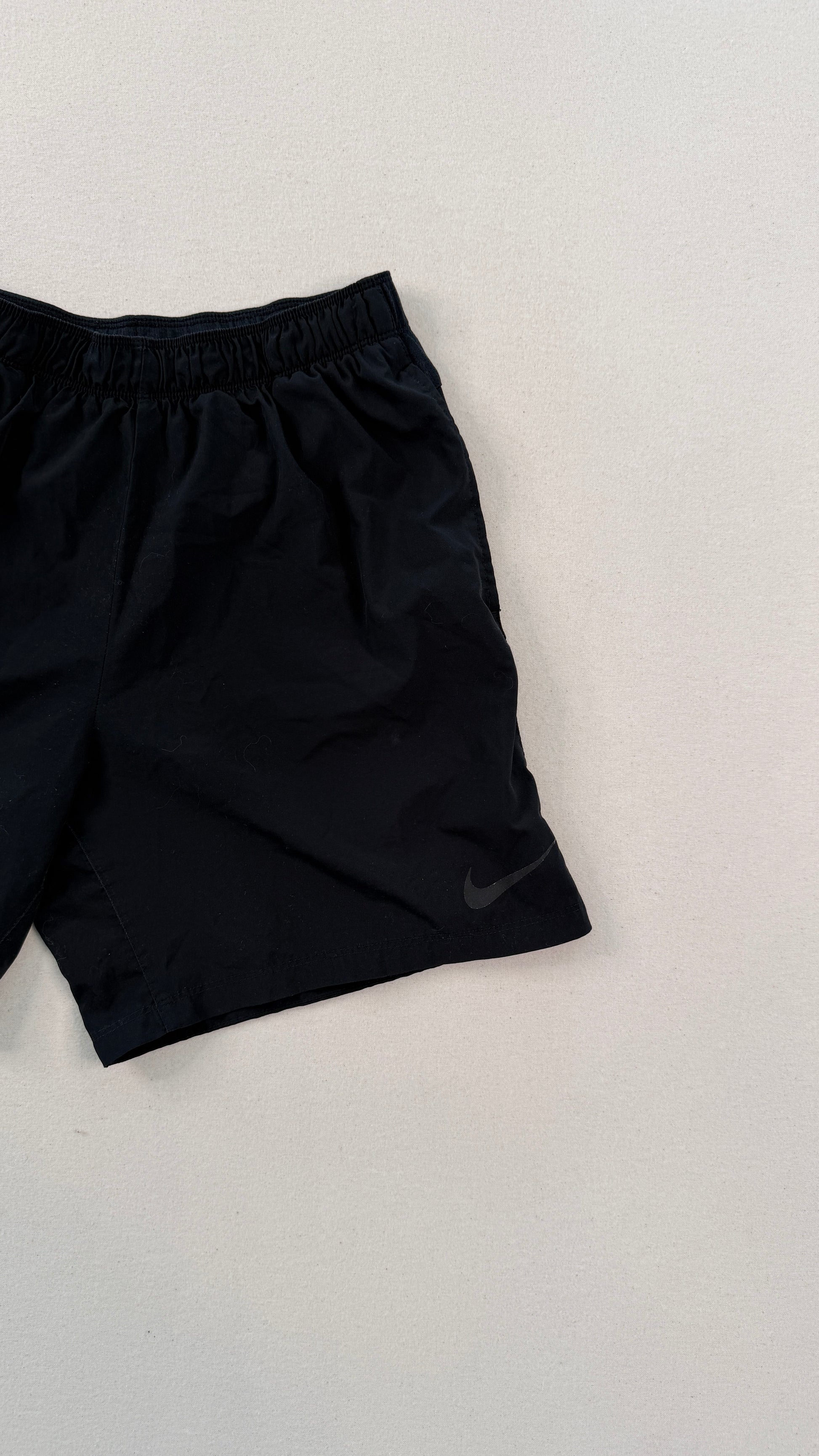 Black Nike shorts on a light gray background