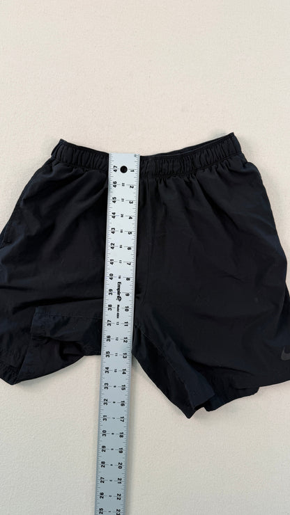Black shorts with a measuring tape on a light gray background