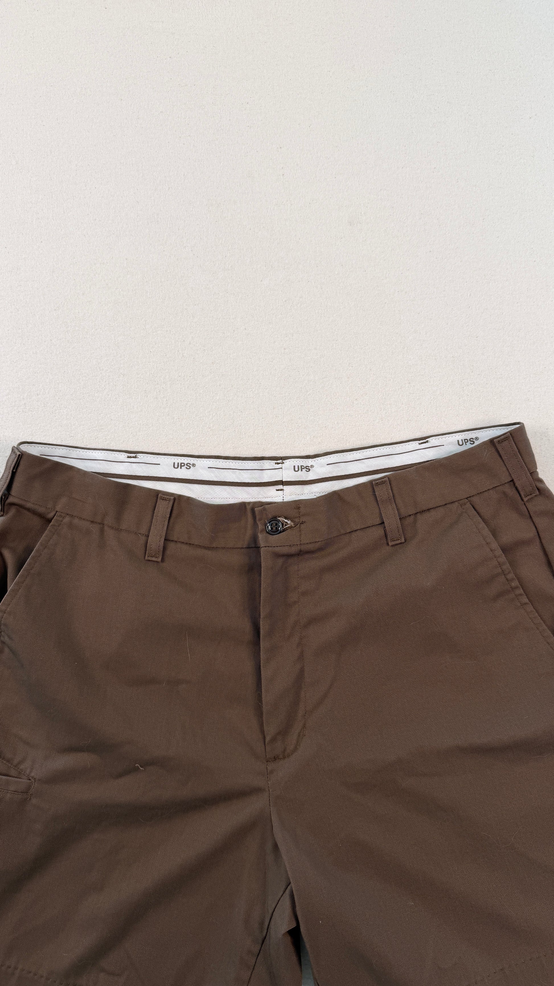 Brown pants with a white waistband on a light gray background