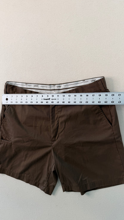 Brown shorts with a ruler for size reference on a light background