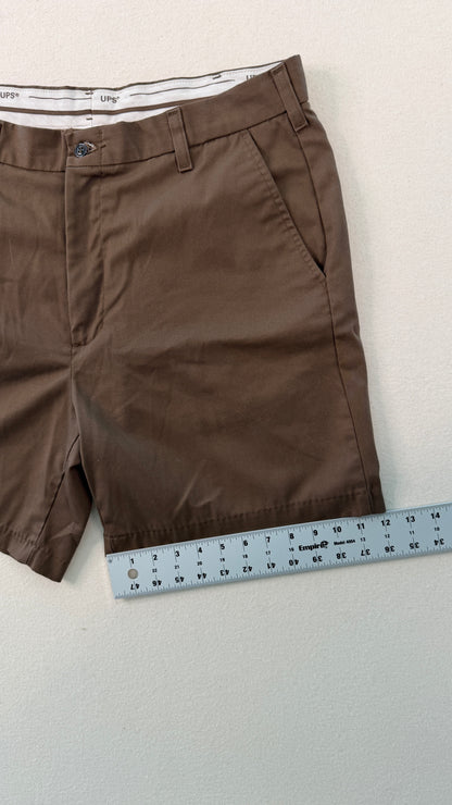 Brown shorts with a measuring tape on a light gray background