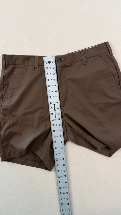 Brown shorts with a measuring tape across them on a light background