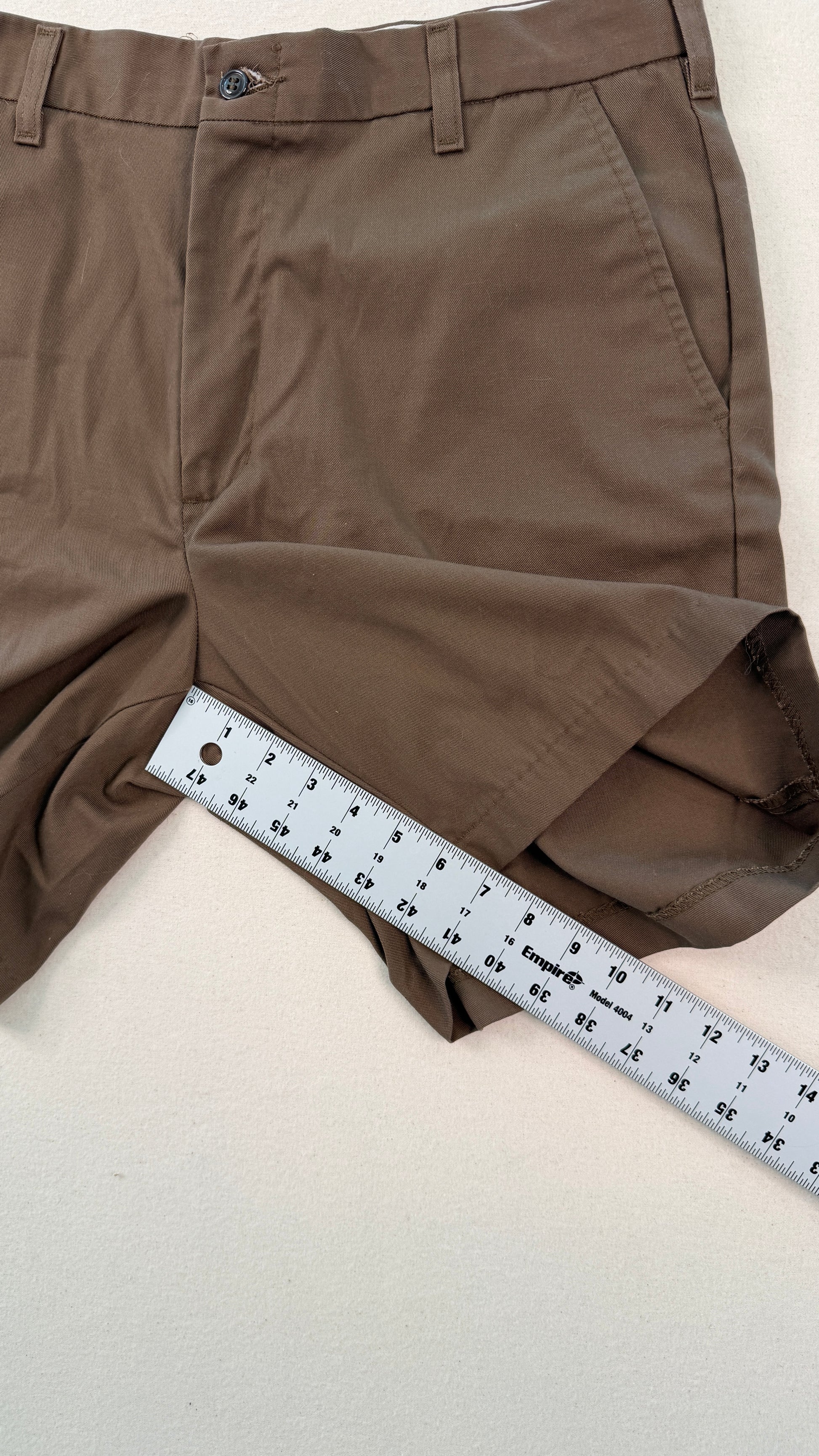 Brown shorts with a ruler for size reference on a light background