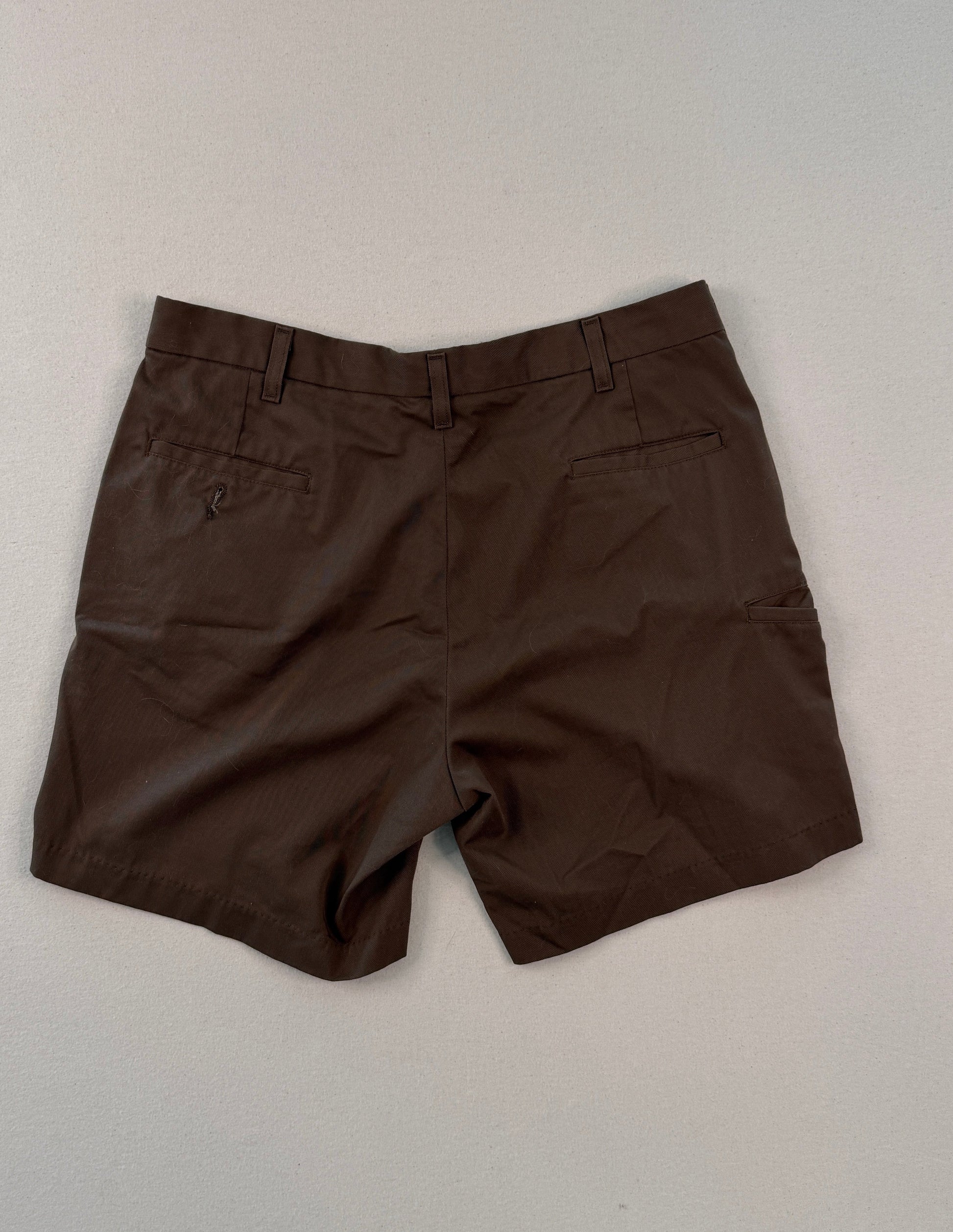 Brown shorts on a light gray surface with a ruler at the bottom.