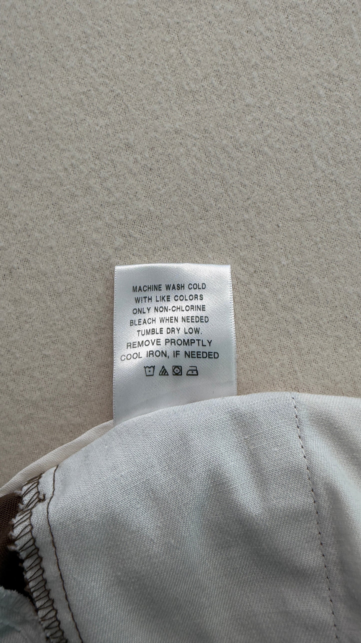 Close-up of a clothing tag on a gray fabric background