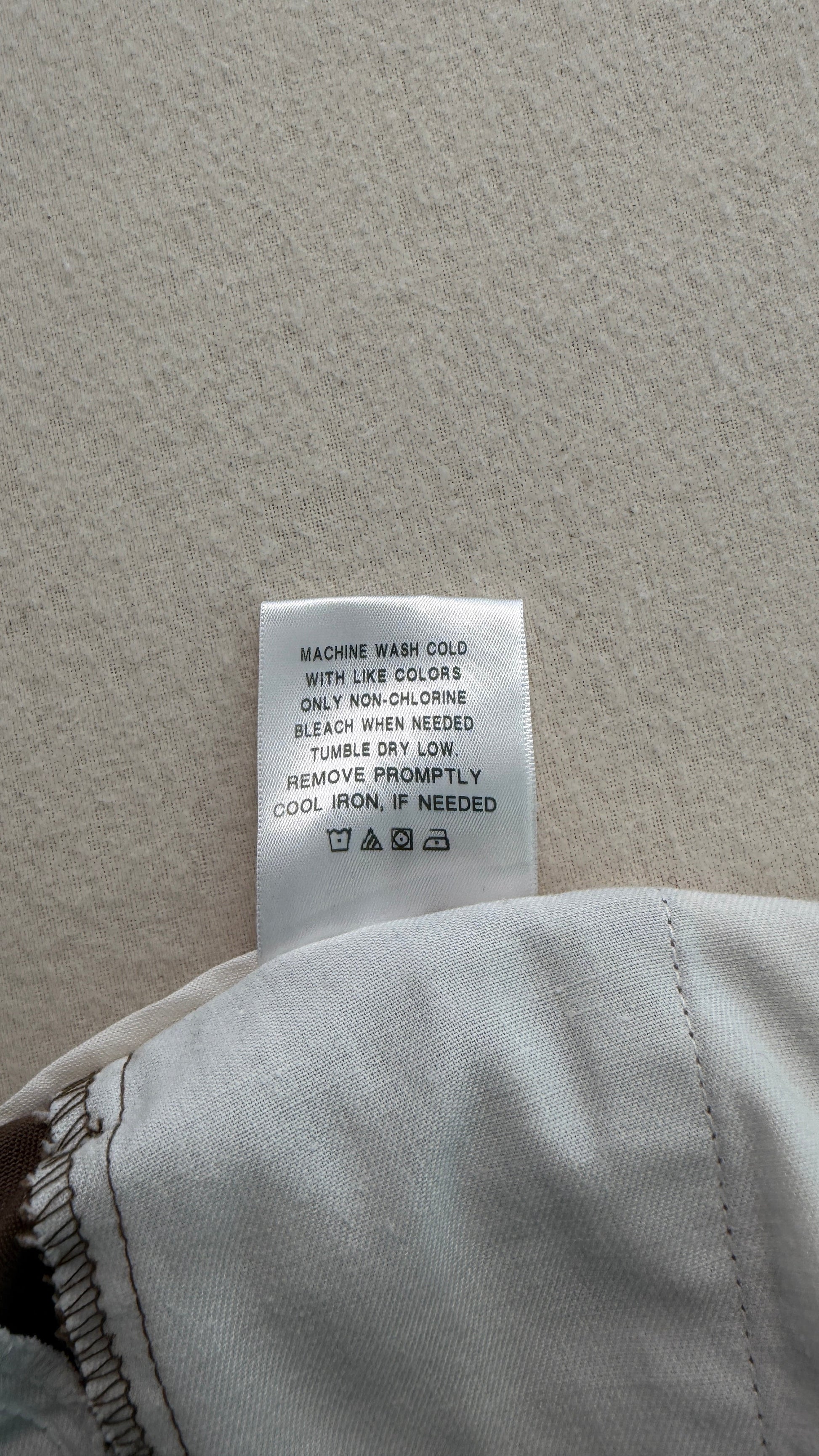 Close-up of a clothing tag on a gray fabric background