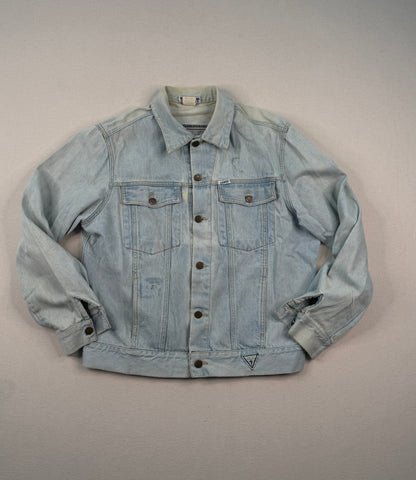 Light blue denim jacket on a gray surface with a neutral background